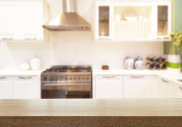Mesa de madera sobre borrosa el fondo de la cocina. - se puede utilizar para mostrar sus productos o carteles promocionales y publicitarios - Foto, Imagen
