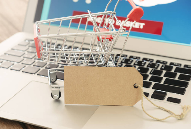 Online vásárlás. Címkék, címkék és bevásárlókocsik egy laptop. Üzleti és modern életmód fogalma. - Fotó, kép