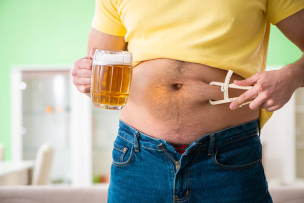 Dikke zwaarlijvige man met bier in dieetconcept - Foto, afbeelding