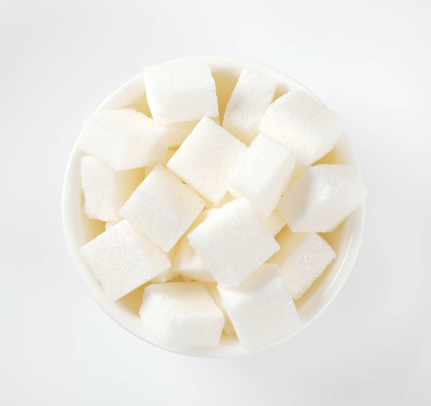 bowl of white sugar cubes on white background - Fotografie, Obrázek