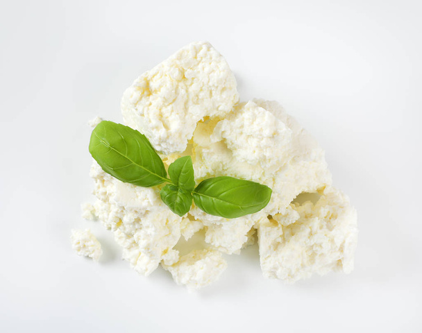 pila de queso blanco desmenuzable sobre fondo blanco
 - Foto, imagen