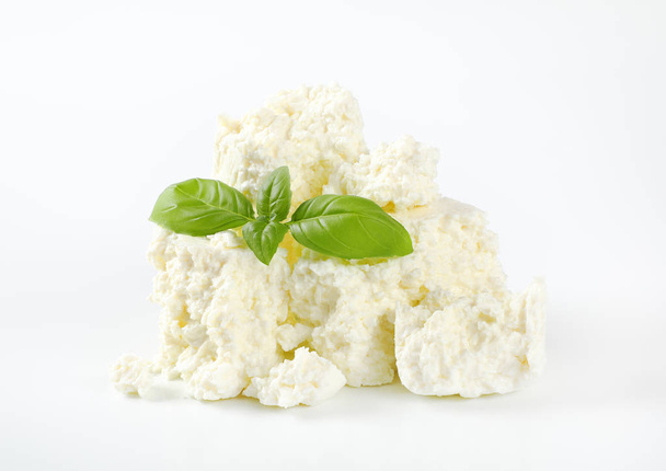 Haufen krümeliger weißer Käse auf weißem Hintergrund - Foto, Bild