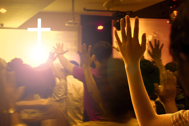 lof en aanbidding concept: handen groeide op in de opwinding en lof op hedendaagse kerk concert en felle lichten - Foto, afbeelding