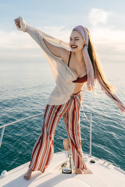 chic happy girl in fashionable clothes enjoys a holiday on a yacht, sails on the Caribbean sea - Foto, Bild