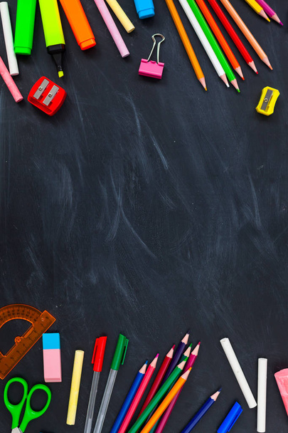 Back To School concept. School supplies on blackboard background, accessories for the schoolroom - pencils, scissors, chalk, markers. Copy space top view - Foto, Imagem
