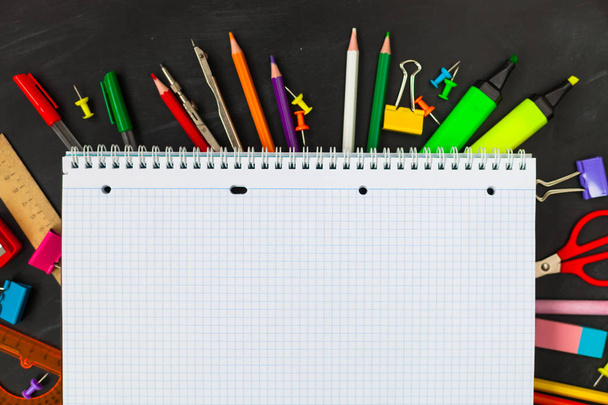 Back To School concept. School supplies on blackboard background, accessories for the schoolroom - pencils, notebooks, scissors, chalk, markers.  Copy space top view - Photo, Image