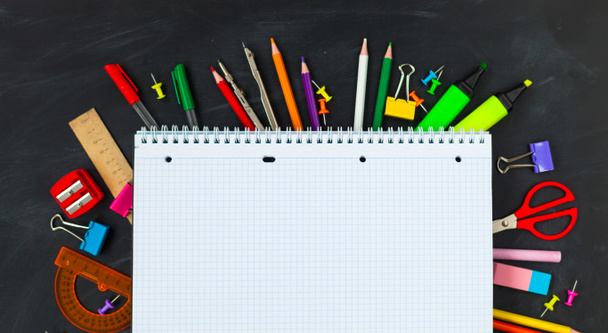 Concept de retour à l'école. Fournitures scolaires sur fond de tableau noir, accessoires pour la salle d'école - crayons, cahiers, ciseaux, craie, marqueurs. Copier l'espace vue supérieure
 - Photo, image