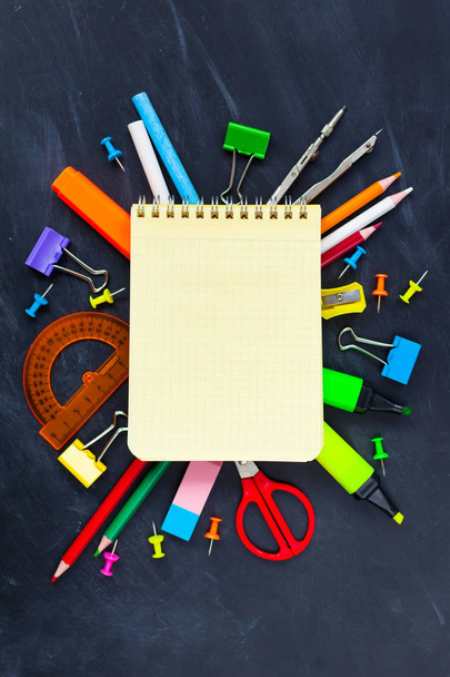 Back To School concept. School supplies on blackboard background, accessories for the schoolroom - pencils, notebooks, scissors, chalk, markers.  Copy space top view - Photo, Image