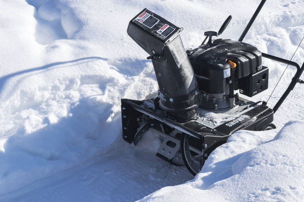 Snowblower at work on a winter day. Snowplow removing snow after blizzard. Clearing the ice. Snow removal machine. Clear driveway with a snowblower. Snow blower. Snow plower. - Zdjęcie, obraz