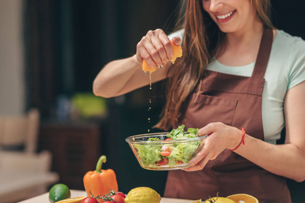 Mosolygó lány készül a saláta, a konyhában - Fotó, kép