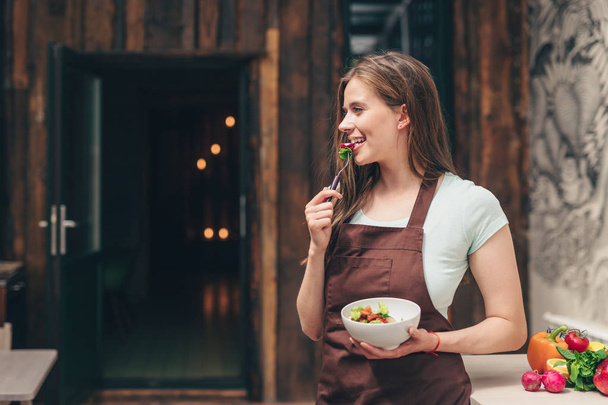 Vonzó nő eszik a konyhában - Fotó, kép