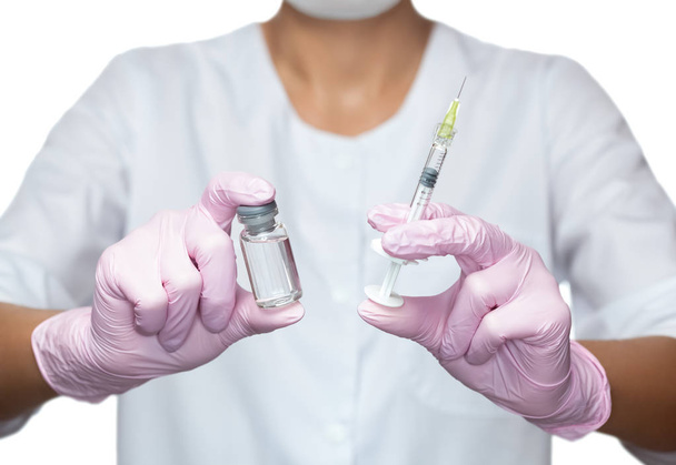 El cosmetólogo médico sostiene una jeringa para inyección y una ampolla con medicamento en el salón de belleza. Cuidado cosmético de la piel
. - Foto, Imagen