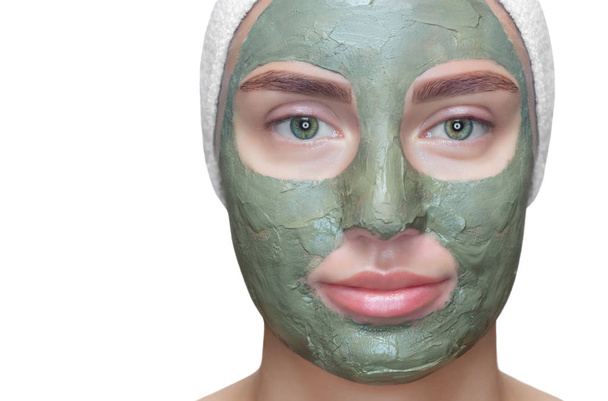 Η διαδικασία για την εφαρμογή μιας μάσκας από πηλό στο πρόσωπο μιας όμορφης γυναίκας. Spa θεραπείες και φροντίδα των γατών στο σαλόνι ομορφιάς. - Φωτογραφία, εικόνα