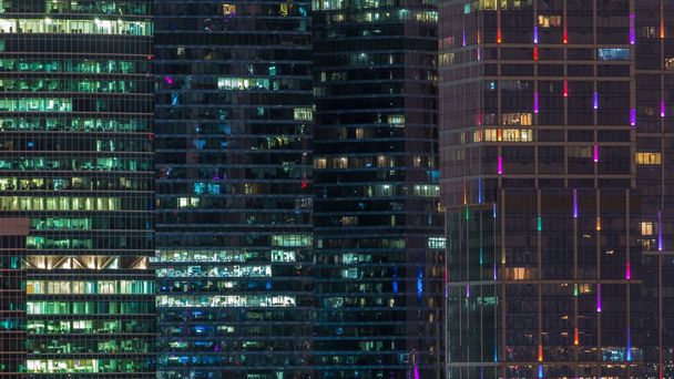 Modern office building with glowing windows at night timelapse. Moscow city. Close up view from rooftop. - Fotó, kép