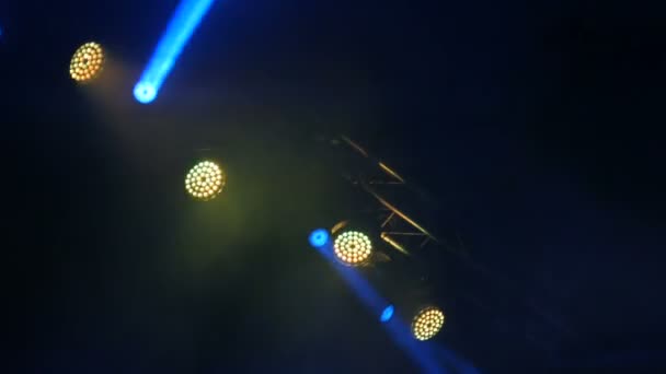 Uma luz azul e amarela piscando na fumaça na cena do concerto de rock
 - Filmagem, Vídeo