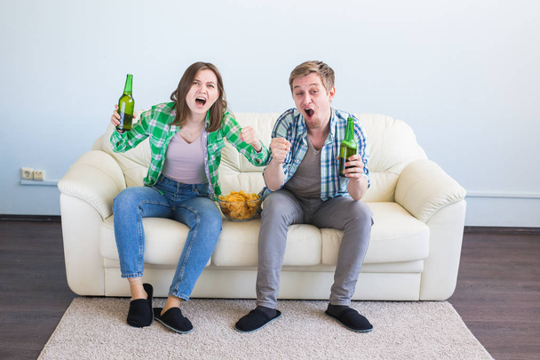 Soccer world cup concept - Couple of friends sitting in sofa watching sport game on tv - Fotoğraf, Görsel