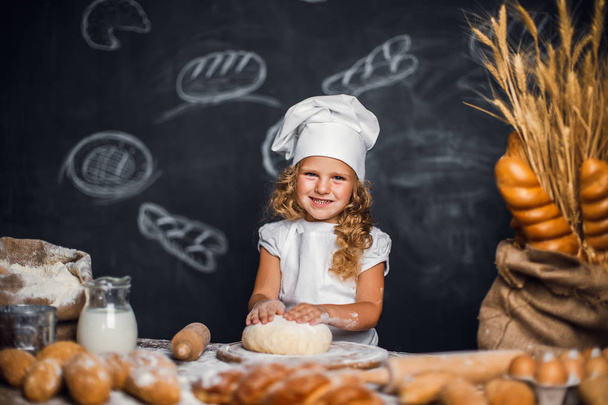 Little girl kneading dough at table - Zdjęcie, obraz