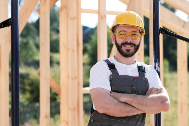 Чоловік будівельник на даху дерев'яного каркасного будинку
. - Фото, зображення