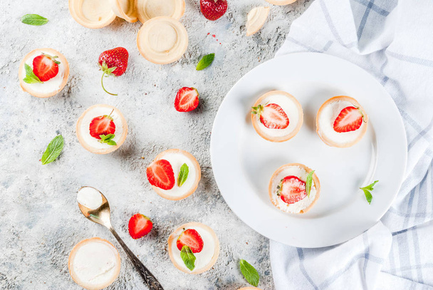 Summer sweet homemade dessert, Mini cheesecakes with strawberry on grey stone table copy space top view - Zdjęcie, obraz