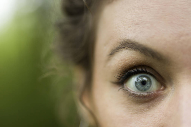 Крупный план глаз молодой женщины на открытом воздухе
 - Фото, изображение