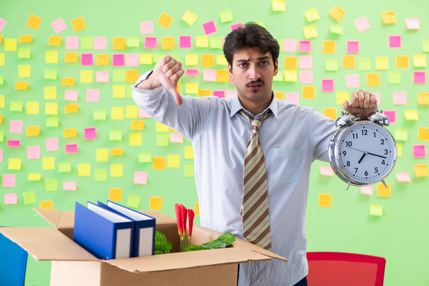 Мужчина собирает свои вещи после увольнения в офисе с мужчиной - Фото, изображение