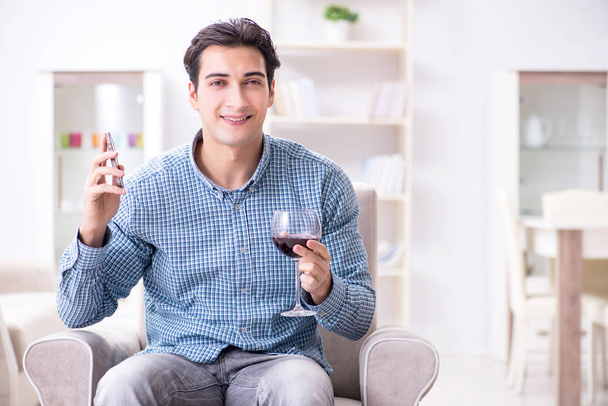 Young man drinking wine at home - Valokuva, kuva