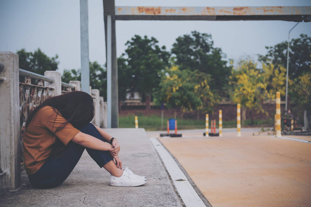 Une femme assise sur le pont se sentant triste et seule
 - Photo, image