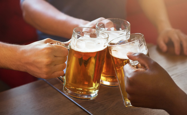 Amigos brindando con vasos de cerveza ligera
 - Foto, imagen