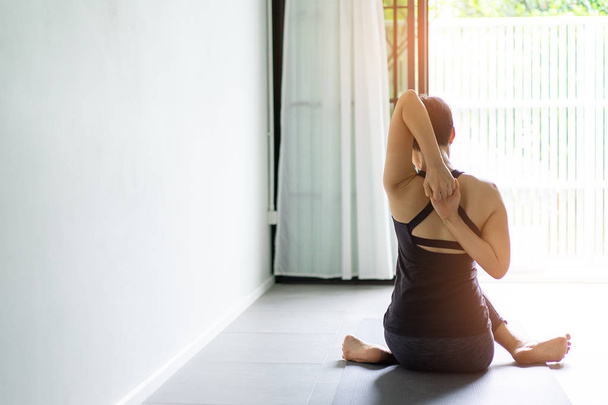 Mladá žena cvičí jógu v šedém pozadí. Mladí lidé dělat jógu vnitřní. - Fotografie, Obrázek