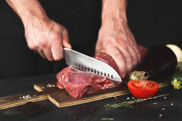 Chef cortando filete mignon en tablero de madera
 - Foto, Imagen