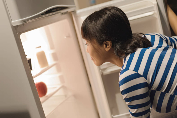 アジアの女性が自宅の冷蔵庫を開く - 写真・画像