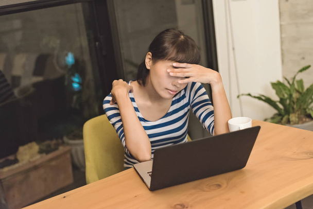 angry Asian young woman using laptop at home - Fotó, kép