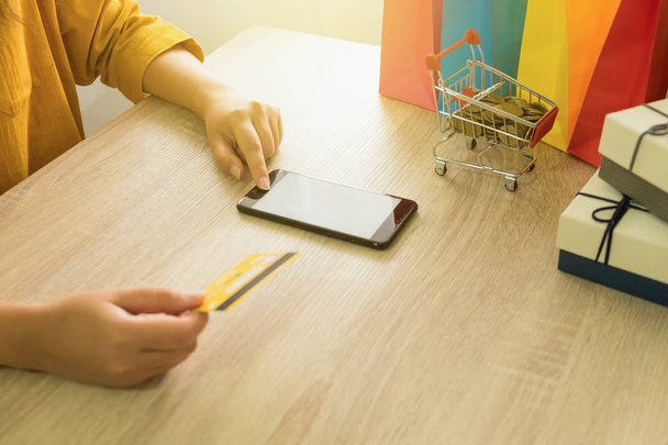 Kredi kartı tutan ve online alışveriş için smartphone kullanarak kadın - Fotoğraf, Görsel