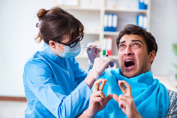 Potilas pelkää hammaslääkäriä lääkärin käynnin aikana - Valokuva, kuva
