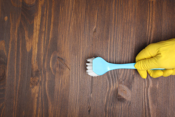 yellow glove and brush on a wooden background - Foto, Imagem