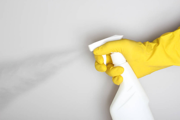 hand yellow glove and white bottle sprayer - Zdjęcie, obraz