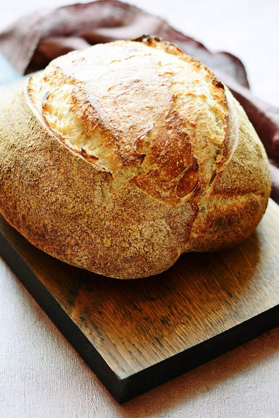 Friss házi kenyér, szürke háttérrel. Ropogós. Francia kenyér. Kenyér kovászban. Kovásztalan kenyér - Fotó, kép