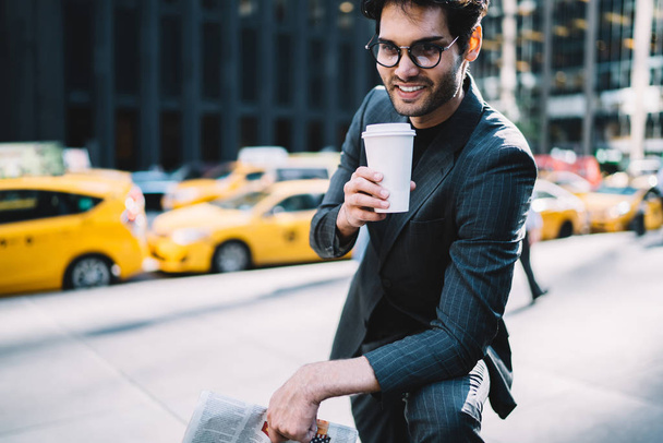 Prosperous businessman in elegant suit and spectacles enjoying aroma coffee to go spending break on Manhattan, Smiling confident male boss in formal outfit holding blank cup satisfied with beverag - Foto, Bild