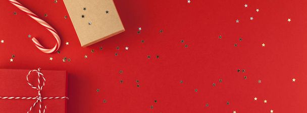 New Year or Christmas presents wrapped ribbon flat lay top view Xmas 2019 holiday celebration handmade gift boxes red paper golden sparkles background copyspace. Template mockup long wide banner - Photo, Image