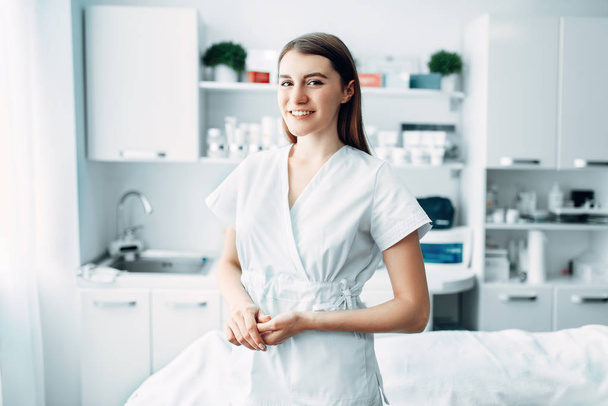 Młoda kobieta kosmetyczka w kosmetologii Szafka. Lekarz w biały uniform w salonie spa, uroda medycyna - Zdjęcie, obraz