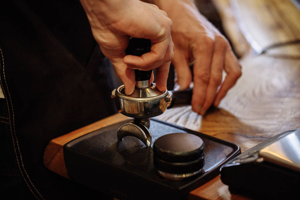 mans hands are grinding coffee - Foto, afbeelding