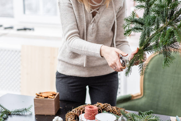 Výrobce vánoční věnec z větví borovice pro dovolenou. Hlavní třída, na to, aby ozdobné ornamenty. Vánoční výzdoba s jejich vlastních rukou. Nový rok oslava. Květinářství - Fotografie, Obrázek