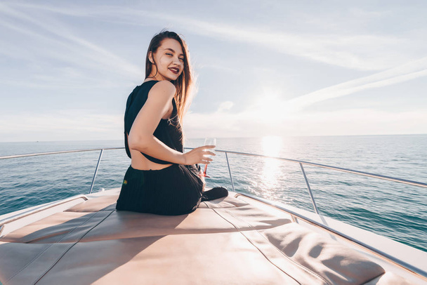 lovely beautiful girl floating on the Caribbean sea, drinking champagne and smiling - Фото, зображення