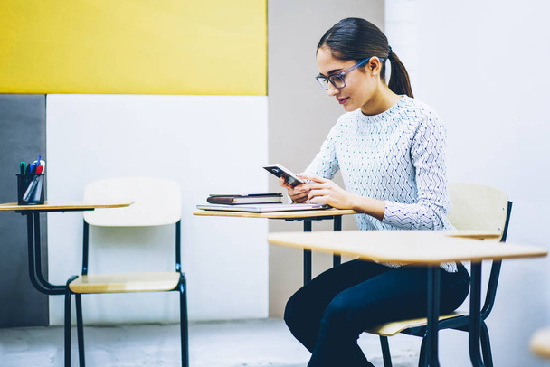 Sosyal ağlarda, sohbet smartphone ile masa başında oturan dalgın genç kadın konsantre kız öğrenci payı multimedya dosyalarını office coworking ara sırasında haber okuma takipçileri ile - Fotoğraf, Görsel