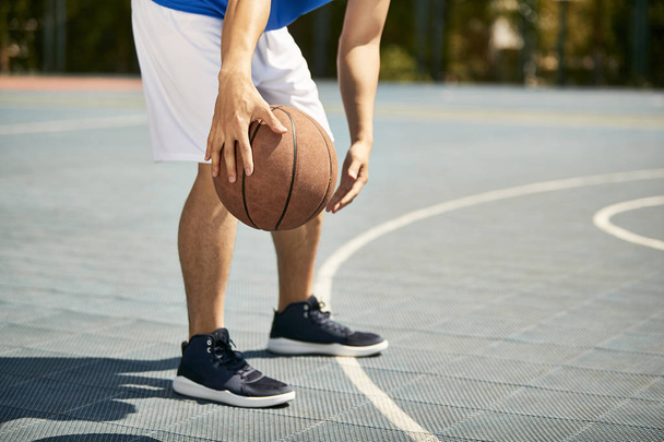 young asian male basketball player dribbling and practicing ball handling skill on court. - 写真・画像