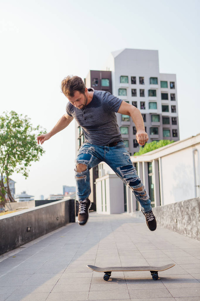 Skateboarder doing a skateboard trick ollie on the street of a city - Fotó, kép