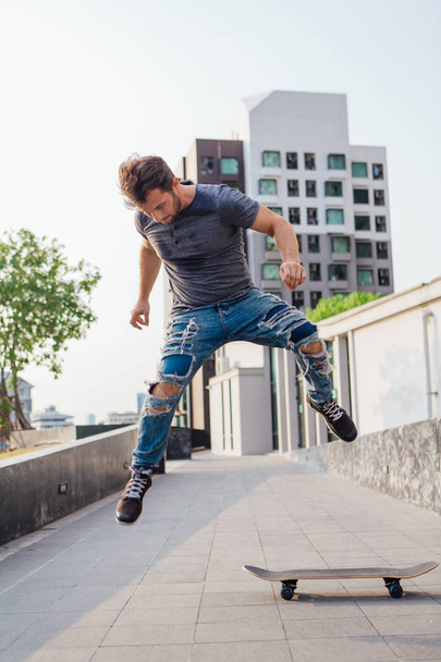 Skateboarder doing a skateboard trick ollie on the street of a city - Foto, imagen