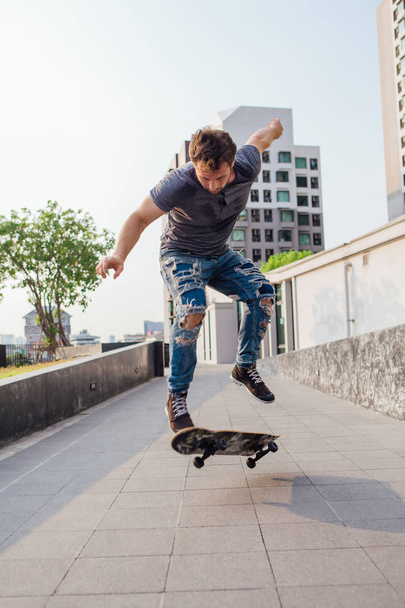Skateboarder doing a skateboard trick ollie on the street of a city - Foto, imagen