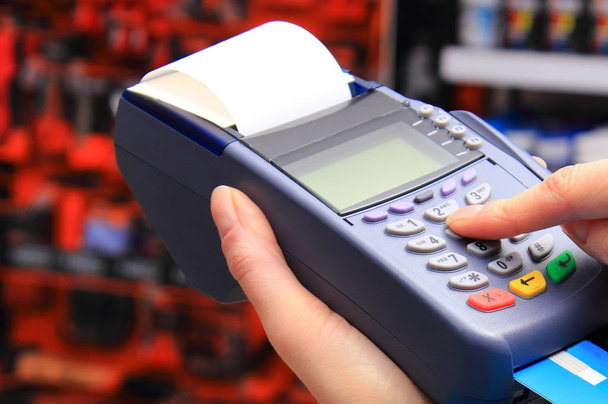 Mano de la mujer que usa la terminal de pago en la tienda, paga con tarjeta de crédito, ingrese el número de identificación personal
 - Foto, Imagen