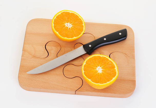 orange pieces on a wooden board and knife - Foto, immagini